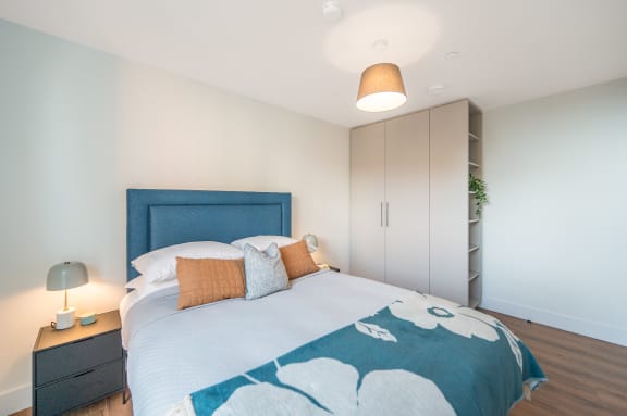 a bedroom with a bed and a blue and white comforter