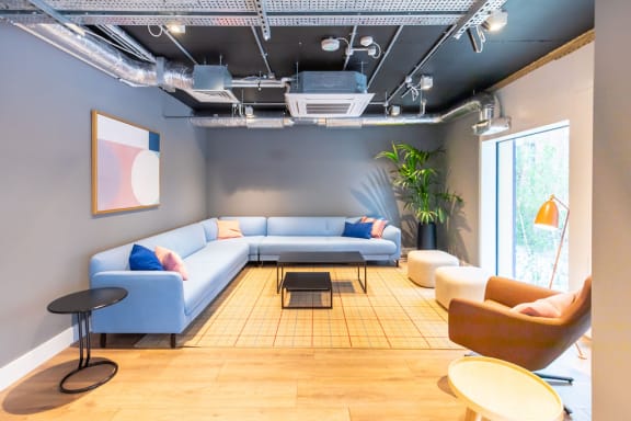a living room with blue couches and chairs and a table