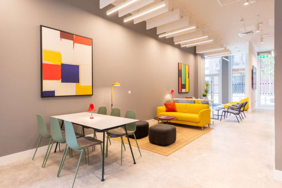 a dining room with a table and chairs and a painting on the wall