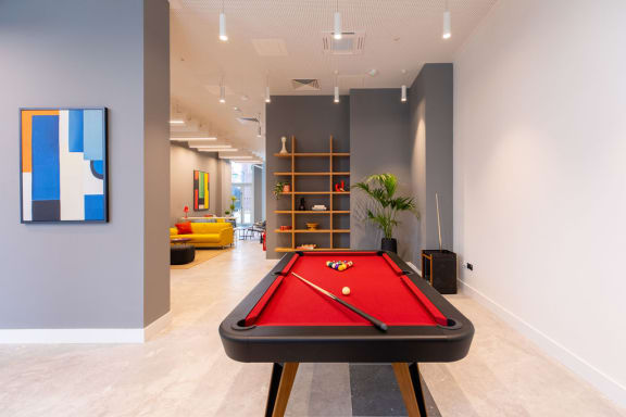 a pool table in a living room with a painting
