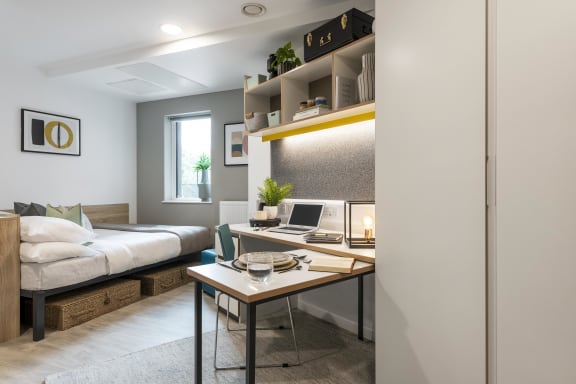 Floor Plan  a home office with a desk and a laptop in a room with a bed