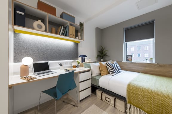 Floor Plan  a bedroom with a bed and a desk with a laptop