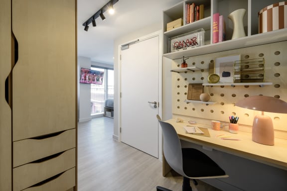 Floor Plan  a home office with a desk and a pegboard on the wall
