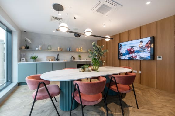 a dining room with a table and chairs and a tv