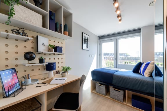Floor Plan  a bedroom with a desk and a bed in a small apartment