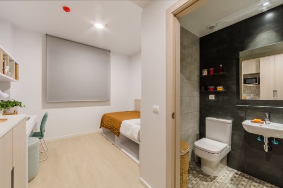 Floor Plan  a bathroom with a toilet and a sink and a bed