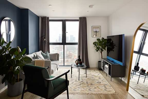 A living room with a green chair and a flat screen TV.