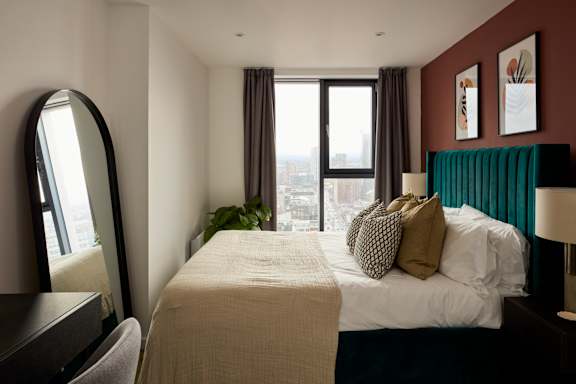 A bedroom with a large bed and a view of the city.