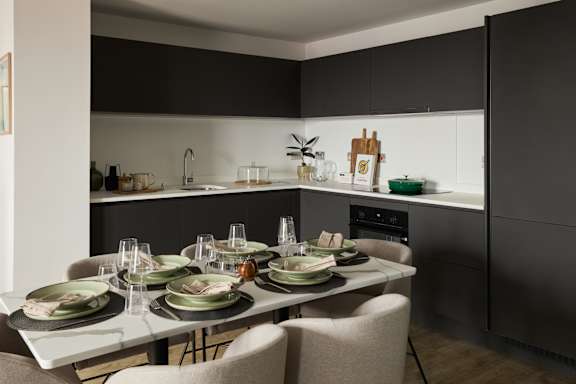 A modern kitchen with a dining table set for a meal.