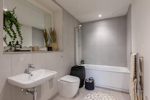A white bathroom with a sink, toilet, and bathtub.