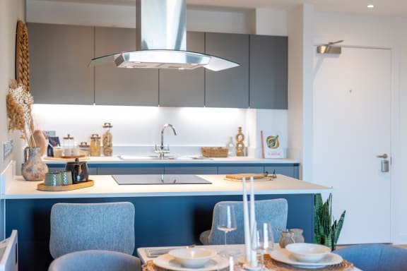 a white kitchen with blue cabinets and a table and chairs