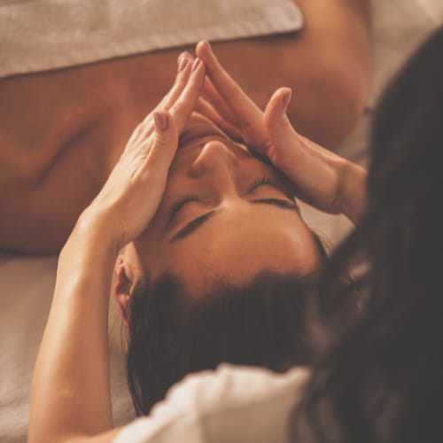 A person is receiving a head massage from another person.