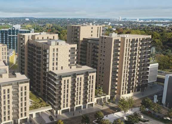 a view of two brick apartment buildings against a blue sky