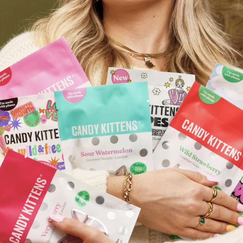 A woman holding several packets of Candy Kittens.