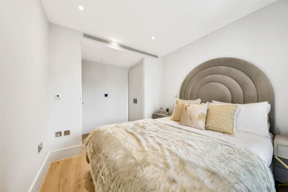 a bedroom with a large bed and a grey headboard
