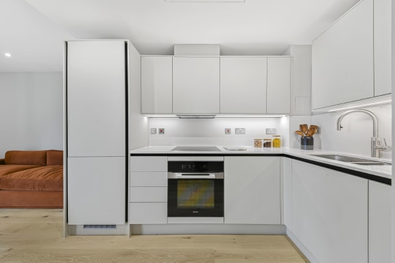 a kitchen with white cabinets and a sink and a stove