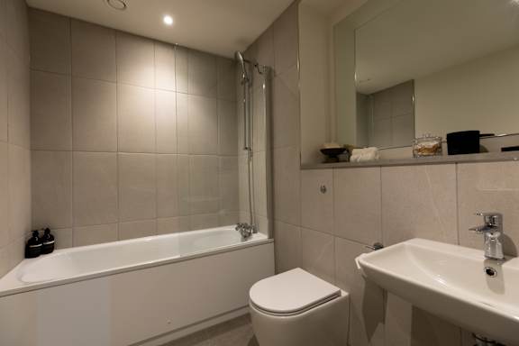 A white bathroom with a toilet, sink, and bathtub.