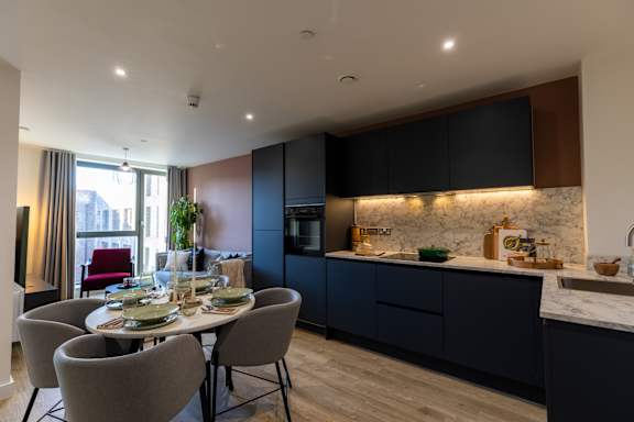 A modern kitchen with a dining table set for four.