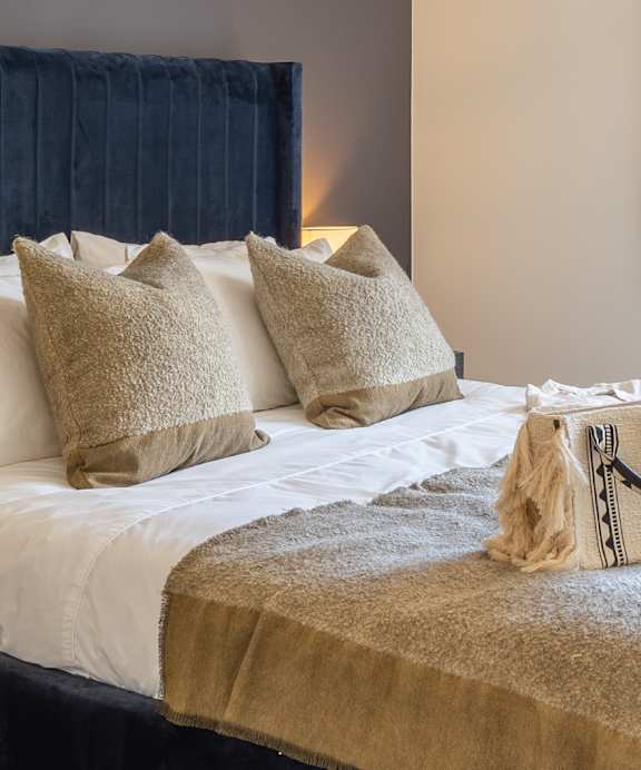 a bedroom with a bed and a lamp on a night stand