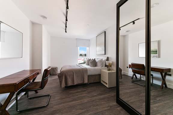 a bedroom with a bed and a desk in a hotel room