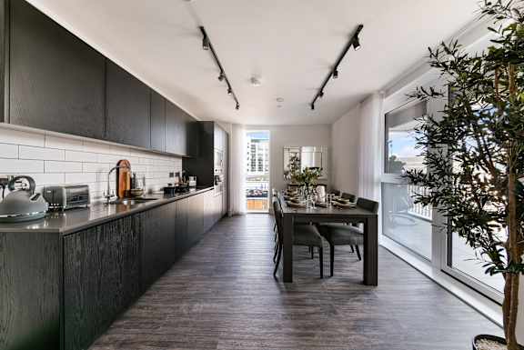 a kitchen with black cabinets and a black dining table