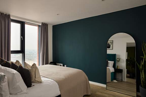 A bedroom with a large bed and a view of the city.