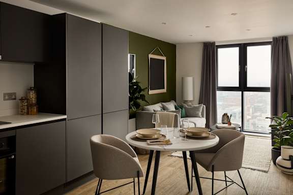 A modern dining room with a table set for two and a view of the city.