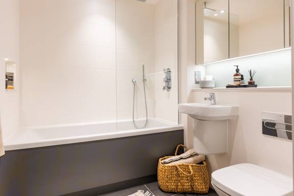 A white bathroom with a white toilet, sink, and bathtub.