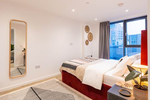 A bedroom with a large bed and a large window.