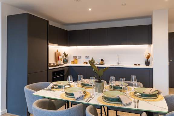 A modern dining room with a glass table set for six.
