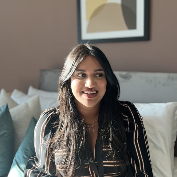 a woman wearing a black jacket sitting on a couch