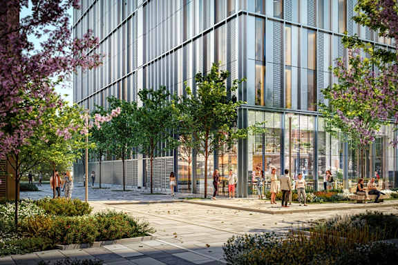 A modern building with glass windows and people walking around outside.