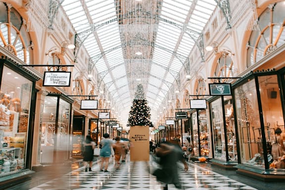 A Christmas tree is in the middle of a shopping mall.