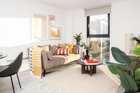 A living room with a grey couch, a coffee table, and a chair.