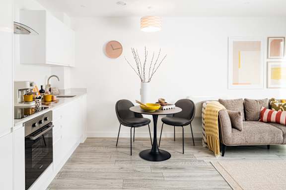 A modern kitchen with a dining table set for two.