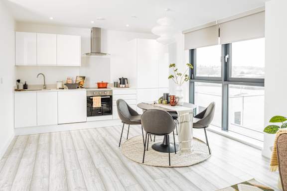 A modern kitchen with a dining table and chairs.