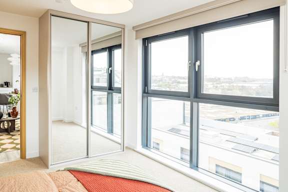 A bedroom with a large bed and a view of the city.
