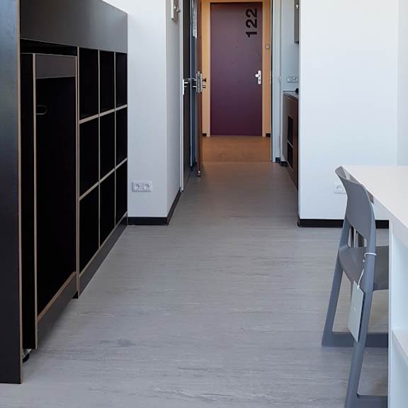 Floor Plan  A hallway with a purple door and a white table and chair.
