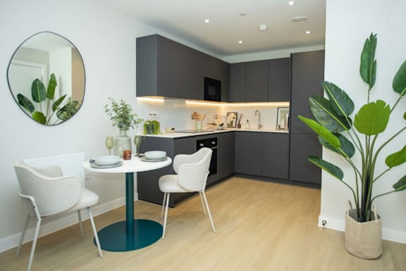 A modern kitchen with a dining table and chairs.
