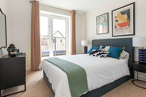 A bedroom with a large bed and a painting on the wall.