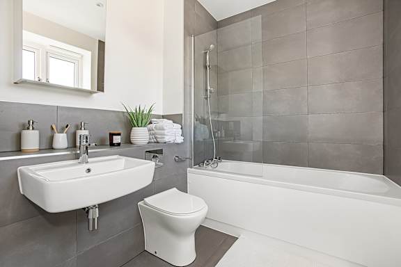 A white toilet sits next to a sink in a modern bathroom.