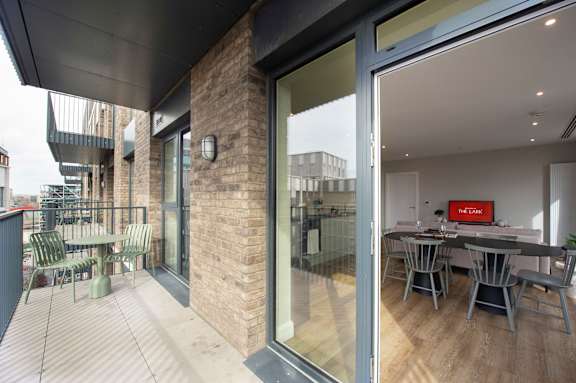 A modern house with a glass door leading to a dining area.