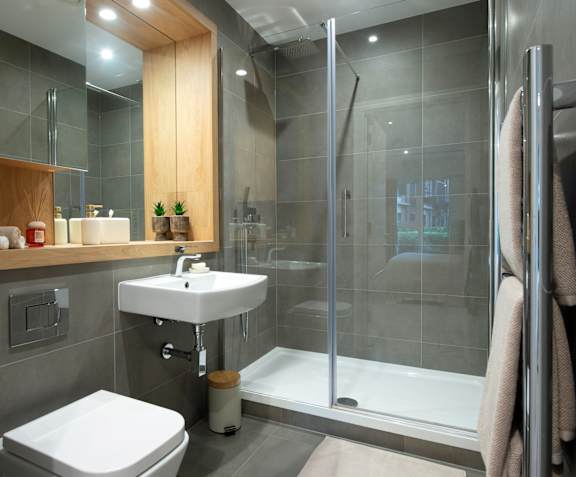 A modern bathroom with a white sink and toilet.