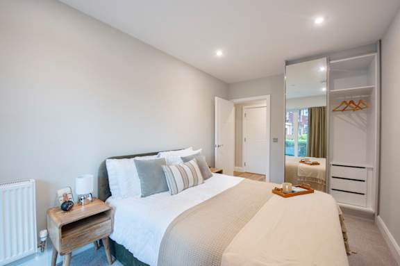 A bedroom with a large bed and a mirror on the wall.