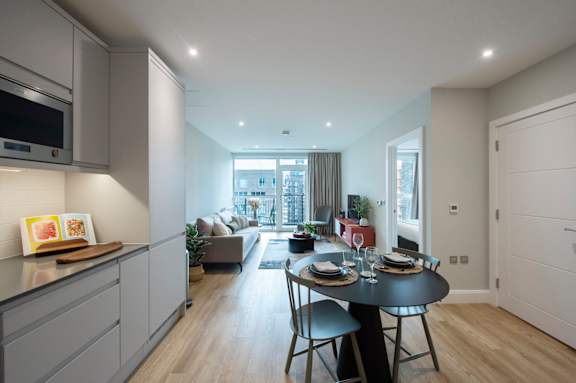 A modern kitchen with a dining table set for two.