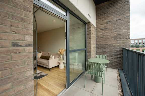 A patio with a table and chairs is visible through a glass door.