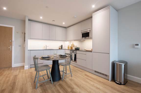 A modern kitchen with a dining table and chairs.