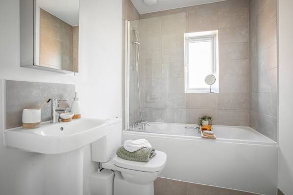 A white bathroom with a toilet, sink, and bathtub.