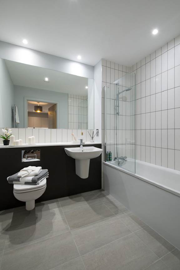 A modern bathroom with a toilet, sink, and bathtub.