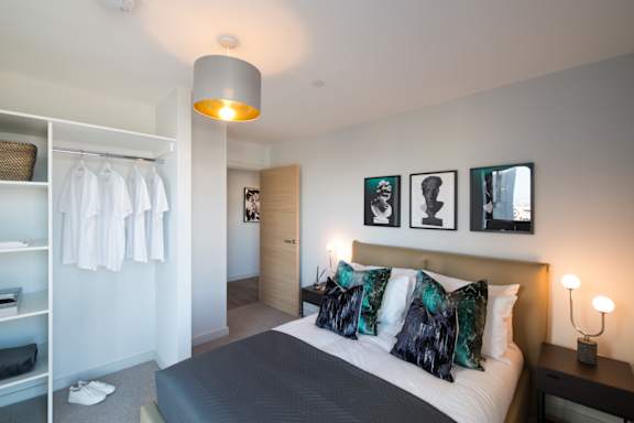 A bedroom with a bed, nightstand, and a lamp.